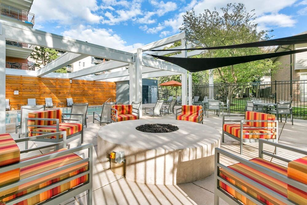 A patio with a fire pit and chairs. at The Lex At Lowry, Denver