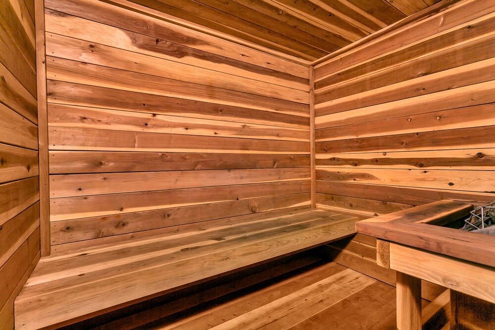 A wooden sauna with a bench and a table. at The Lex At Lowry, Denver, CO