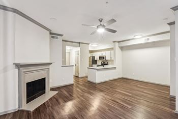 A room with a fireplace and a ceiling fan.at Onyx183, Austin, 78729  