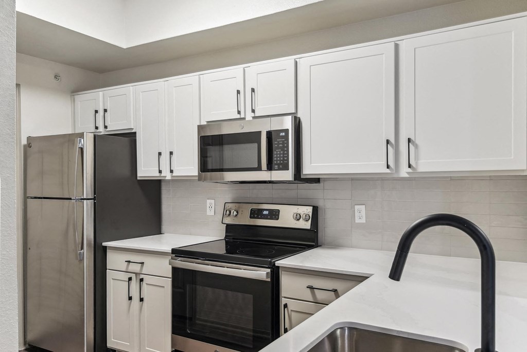 A kitchen with white cabinets and black appliances. A kitchen with white cabinets and black appliances.at Onyx183, Austin, TX