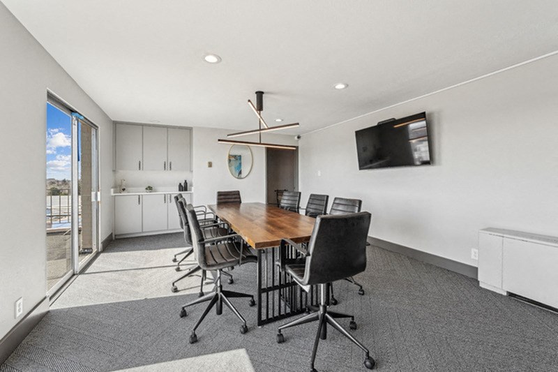 A conference room with a long table and chairs. at The Lex At Lowry, Denver, CO, 80224