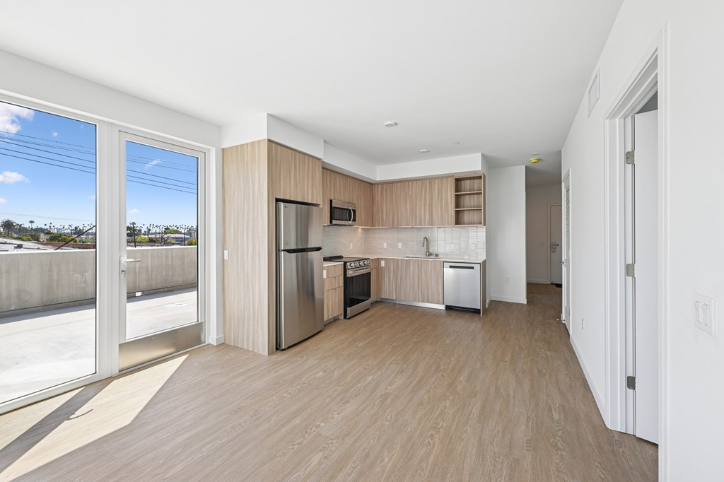 A kitchen with wooden floors and a refrigerator at Coro Apartments, California