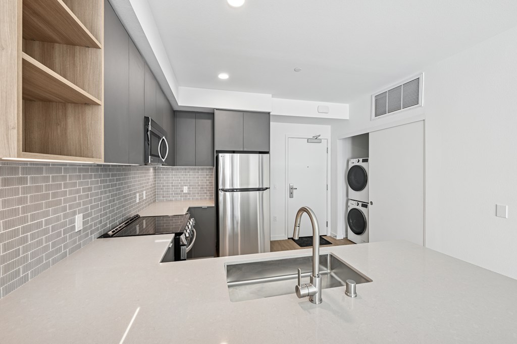 A modern kitchen with a stainless steel refrigerator and a sink at Coro Apartments, California 90016