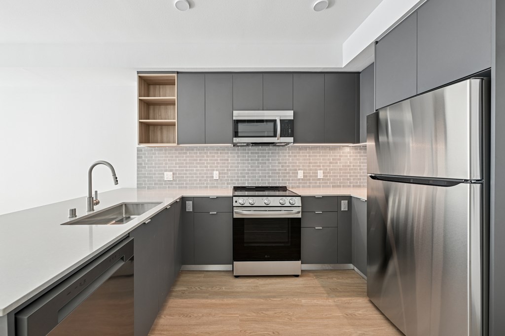 A modern kitchen with a stainless steel refrigerator at Coro Apartments, Los Angeles, 90016