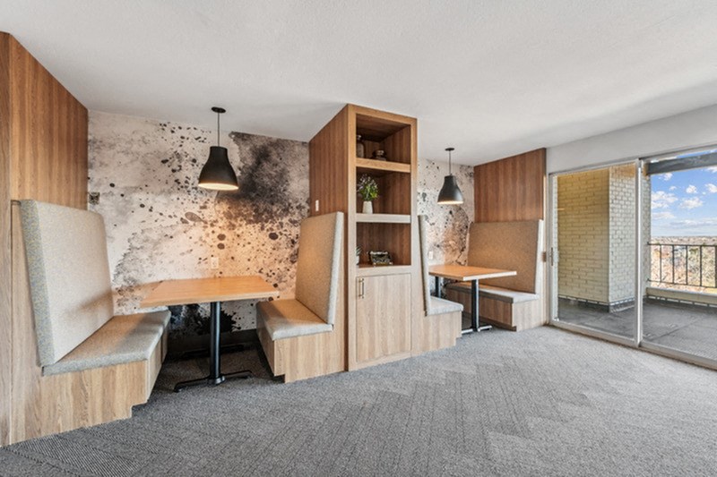 A room with a table, chairs and a wall with a unique design. at The Lex At Lowry, Denver, Colorado