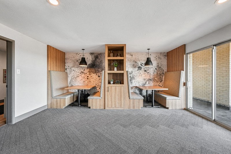A room with a grey carpet and a wooden bookshelf. at The Lex At Lowry, Denver, 80224