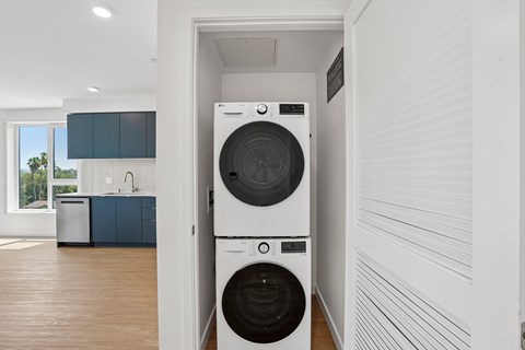 A white washing machine is in a small room.