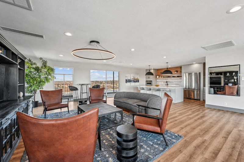 A modern living room with brown leather chairs and a wooden floor. at The Lex At Lowry, Denver, Colorado