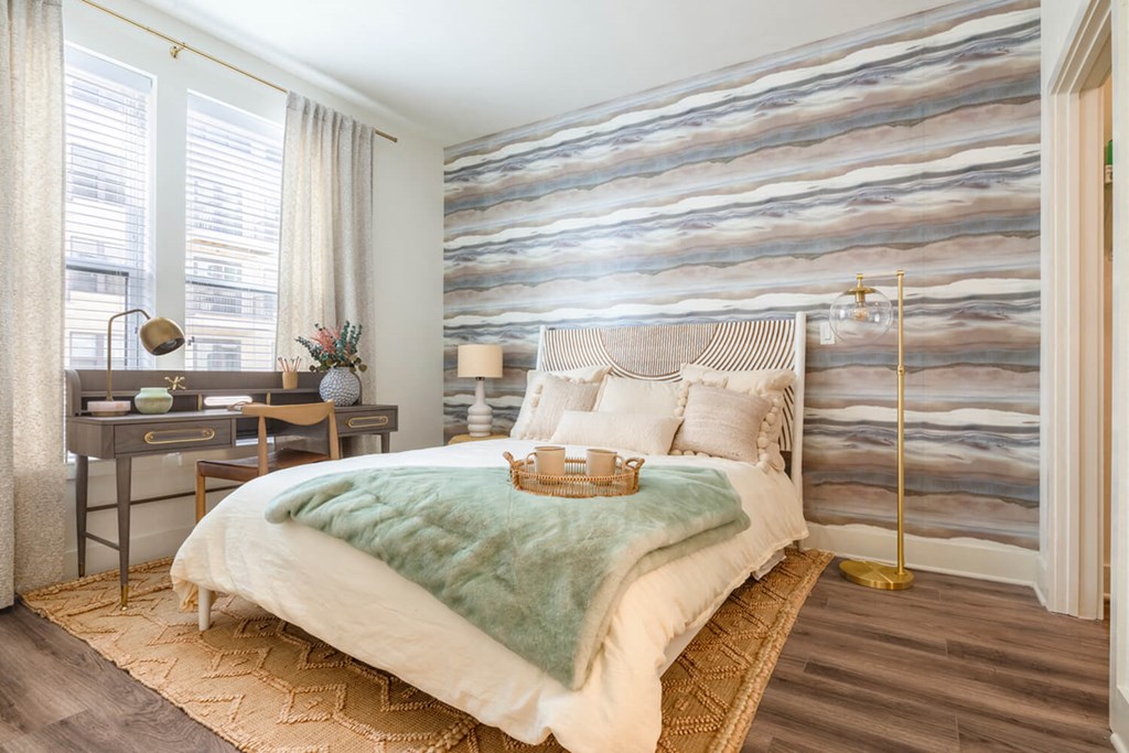 A bedroom with a large bed and a desk with a lamp. A bedroom with a large bed and a desk with a lamp.at The Vale at the Parks, Washington, DC