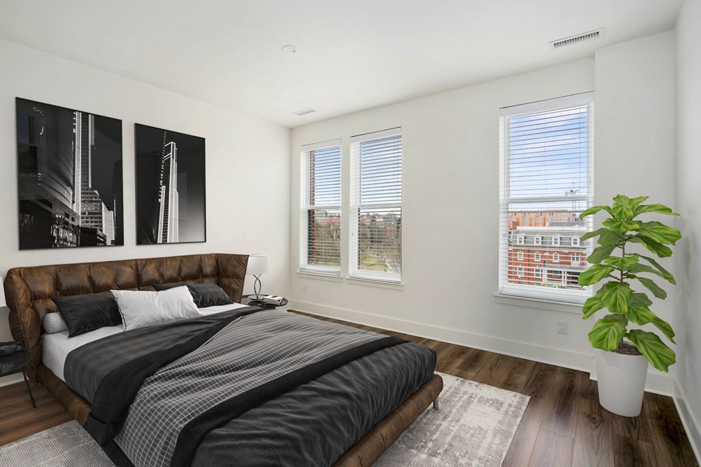 A bedroom with a large bed and a plant.at The Vale at the Parks, District of Columbia  
