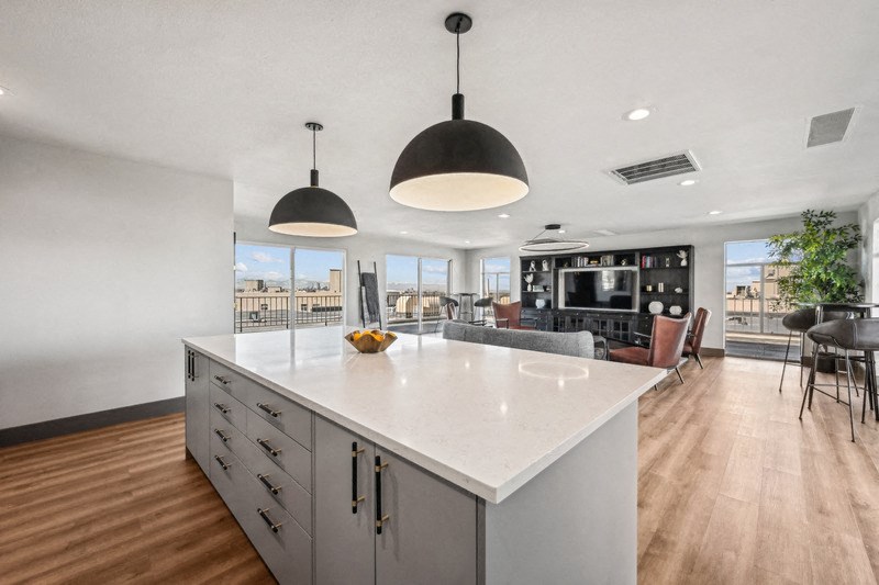A modern kitchen with a large island and pendant lights. at The Lex At Lowry, Denver