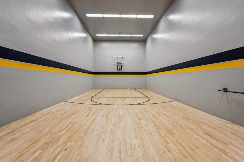 A basketball court with a wooden floor and a basketball hoop. at The Lex At Lowry, Denver, CO, 80224