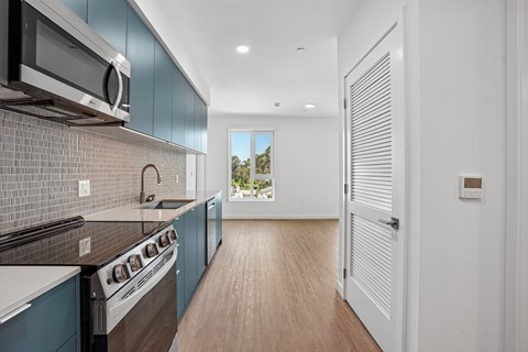 A modern kitchen with dark blue cabinets and a white stove top oven.
