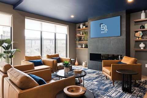 A living room with a blue carpet and a fireplace.