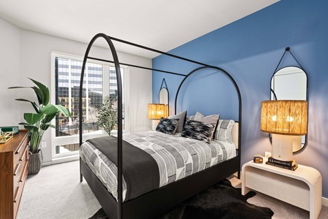 Bedroom with canopy bed and blue accent wall at 51 South Apartments, White Plains, NY 10601