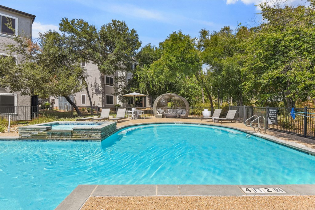 A swimming pool surrounded by trees and chairs. A swimming pool surrounded by trees and chairs.at Onyx183, Austin, 78729