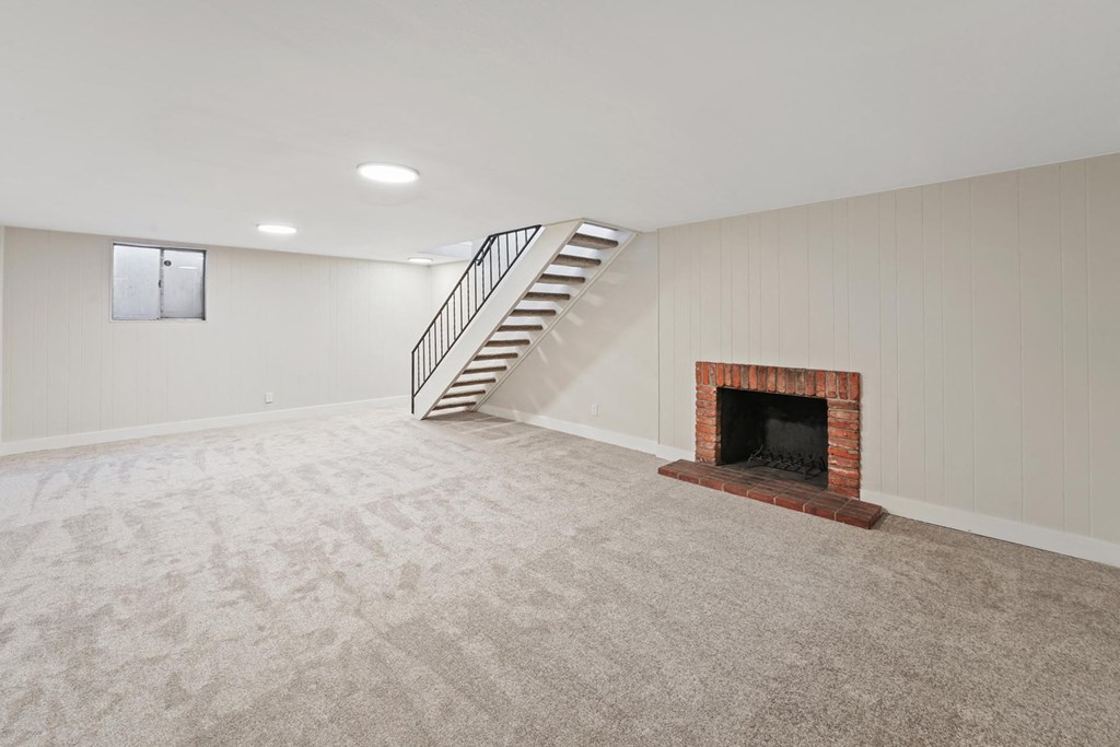 A room with a fireplace and a staircase. at The Lex At Lowry, Colorado, 80224
