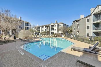 A pool surrounded by apartment buildings and a sun lounger.at Onyx183, Austin Texas  