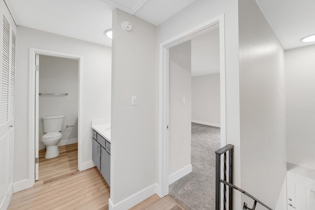 A white bathroom with a toilet and sink. at The Lex At Lowry, Denver
