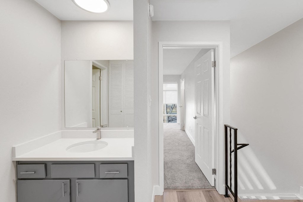 A bathroom with a sink, mirror, and cabinets. at The Lex At Lowry, Denver, CO, 80224
