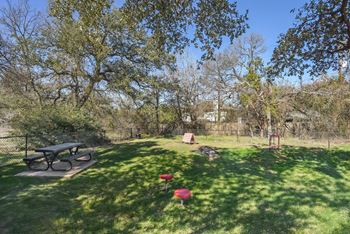 A park with a picnic table and a red object on the grass.at Onyx183, Texas  
