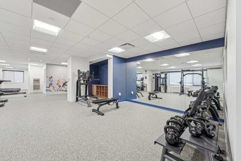 A gym with a variety of equipment including dumbbells and weight machines.