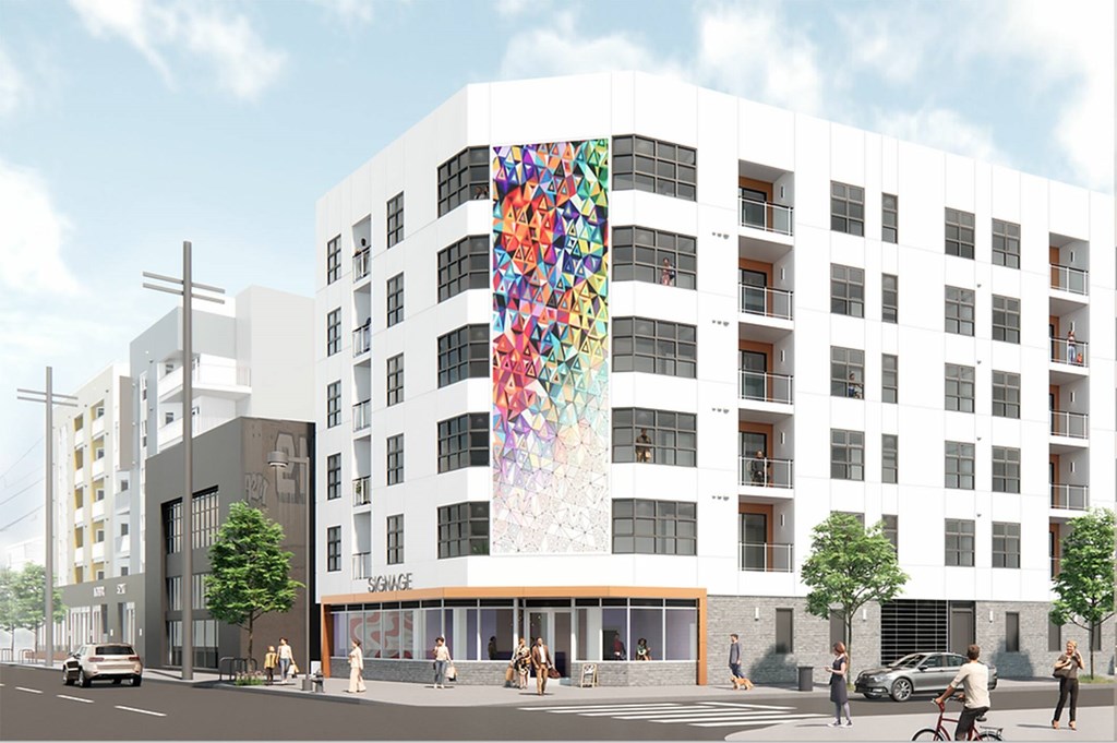 A white building with a mural on the side of it.