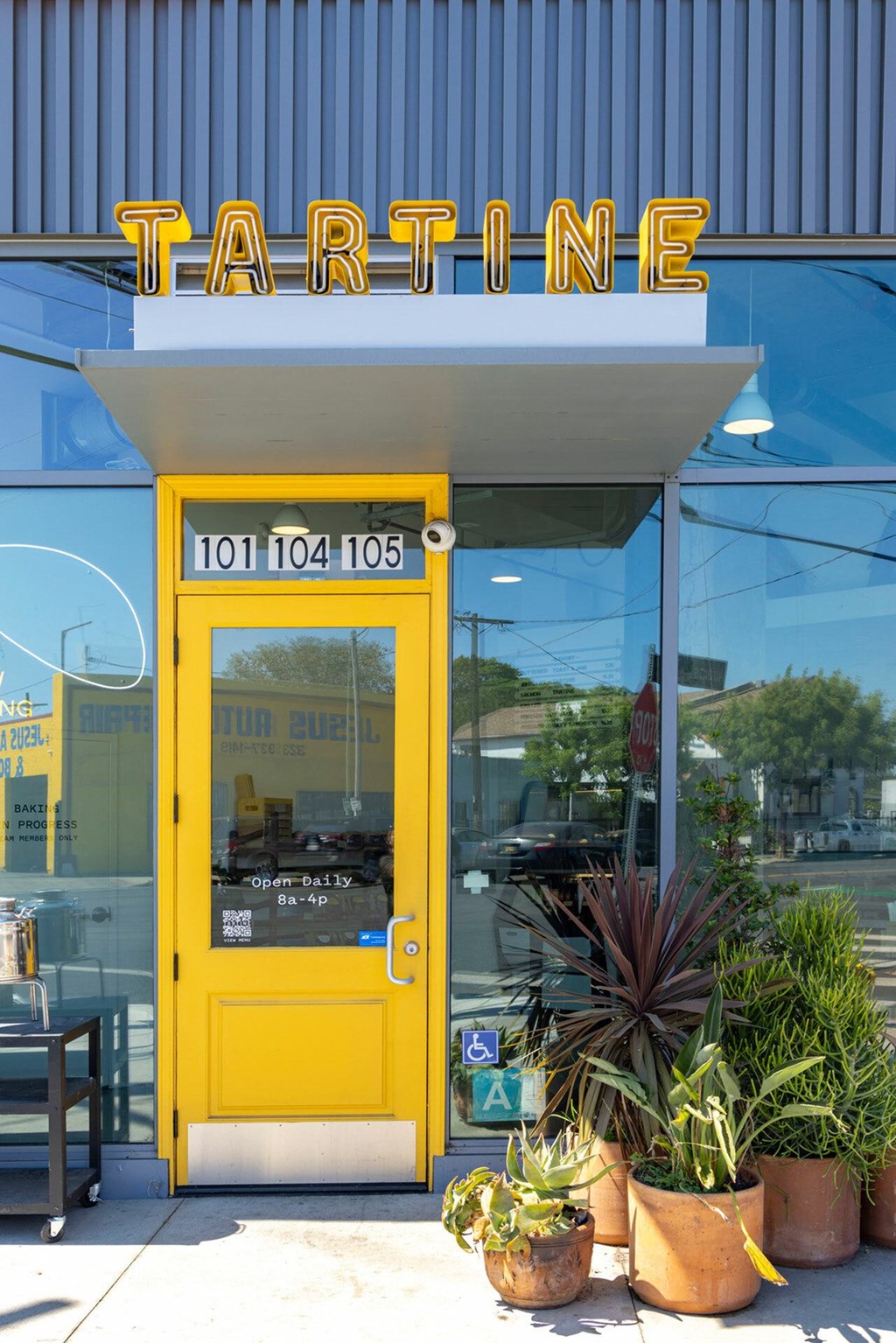 A yellow door with a sign above it that says Tartine.