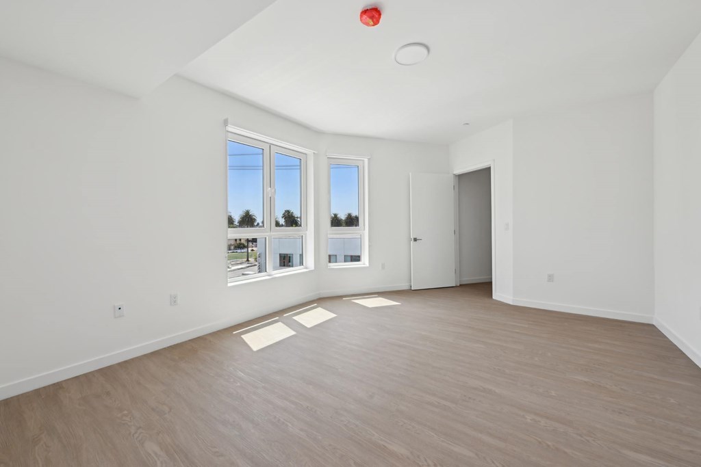 A room with a red light on the ceiling and a view of the outside through the windows.