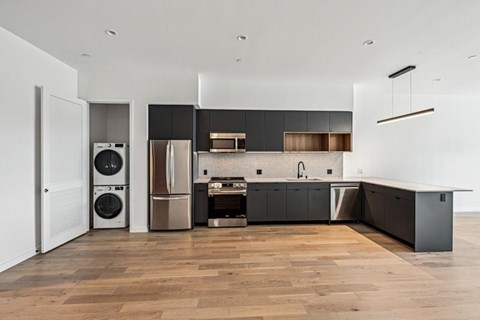 A modern kitchen with dark wood cabinets and stainless steel appliances.