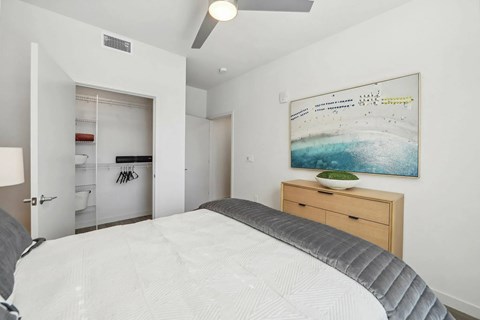 A bedroom with a large bed and a painting on the wall.