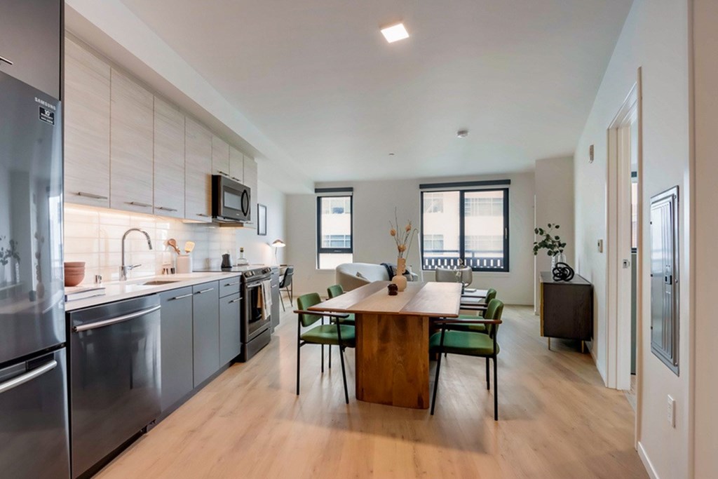 A modern kitchen with stainless steel appliances and wooden flooring.at Channel House, Oakland, CA