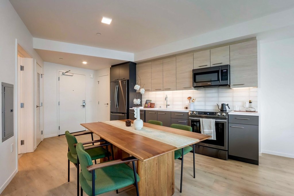 A modern kitchen with a dining table and chairs.at Channel House, Oakland, 94607