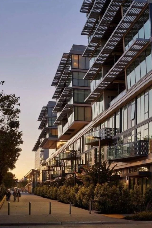 A modern building with a glass facade and a wooden balcony. at Channel House, Oakland, 94607