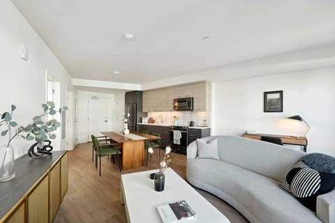 A modern living room with a grey sofa and a wooden coffee table.