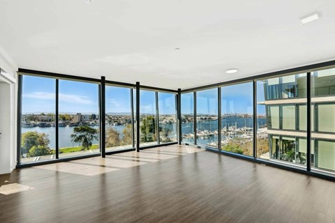 A spacious room with large windows overlooking a body of water.