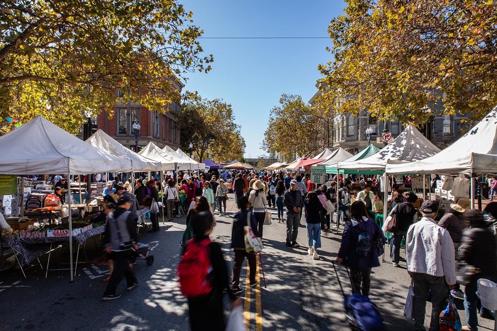 A busy street market with people walking around and shopping.at Channel House, California