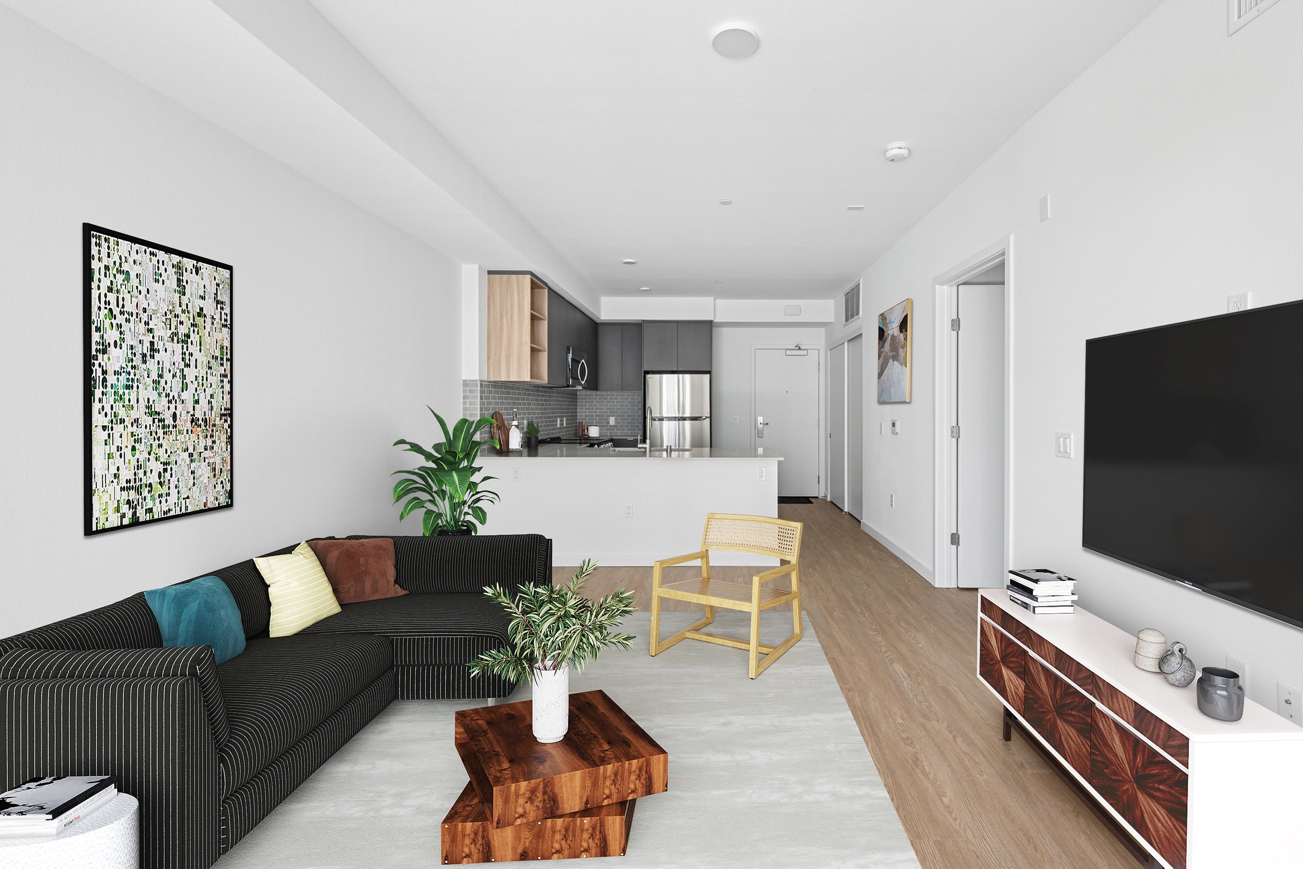 A living room with a black couch and a wooden coffee table.