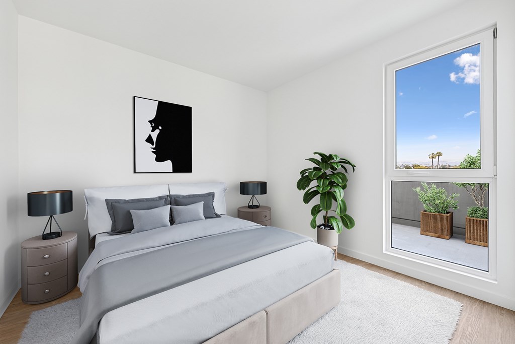 A bedroom with a large bed and a painting on the wall at Coro Apartments, California 90016
