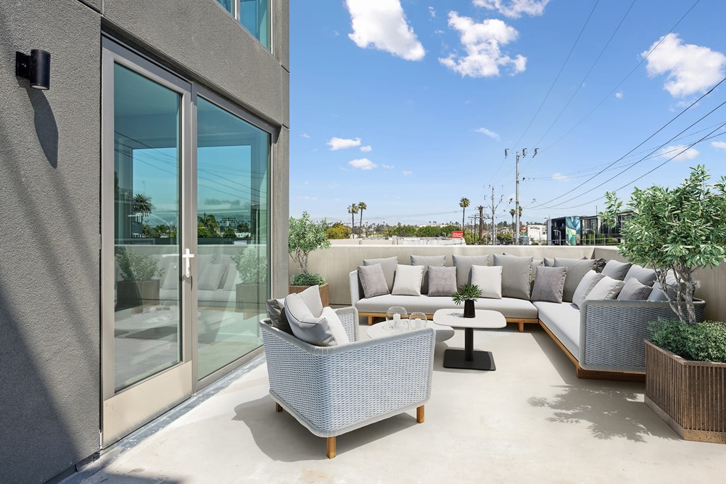 A patio with a couch, chairs, and a table at Coro Apartments, Los Angeles, 90016