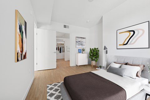 A bedroom with a large bed and a painting on the wall at Coro Apartments, Los Angeles