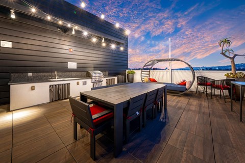 A modern outdoor dining area with a wooden table and chairs.