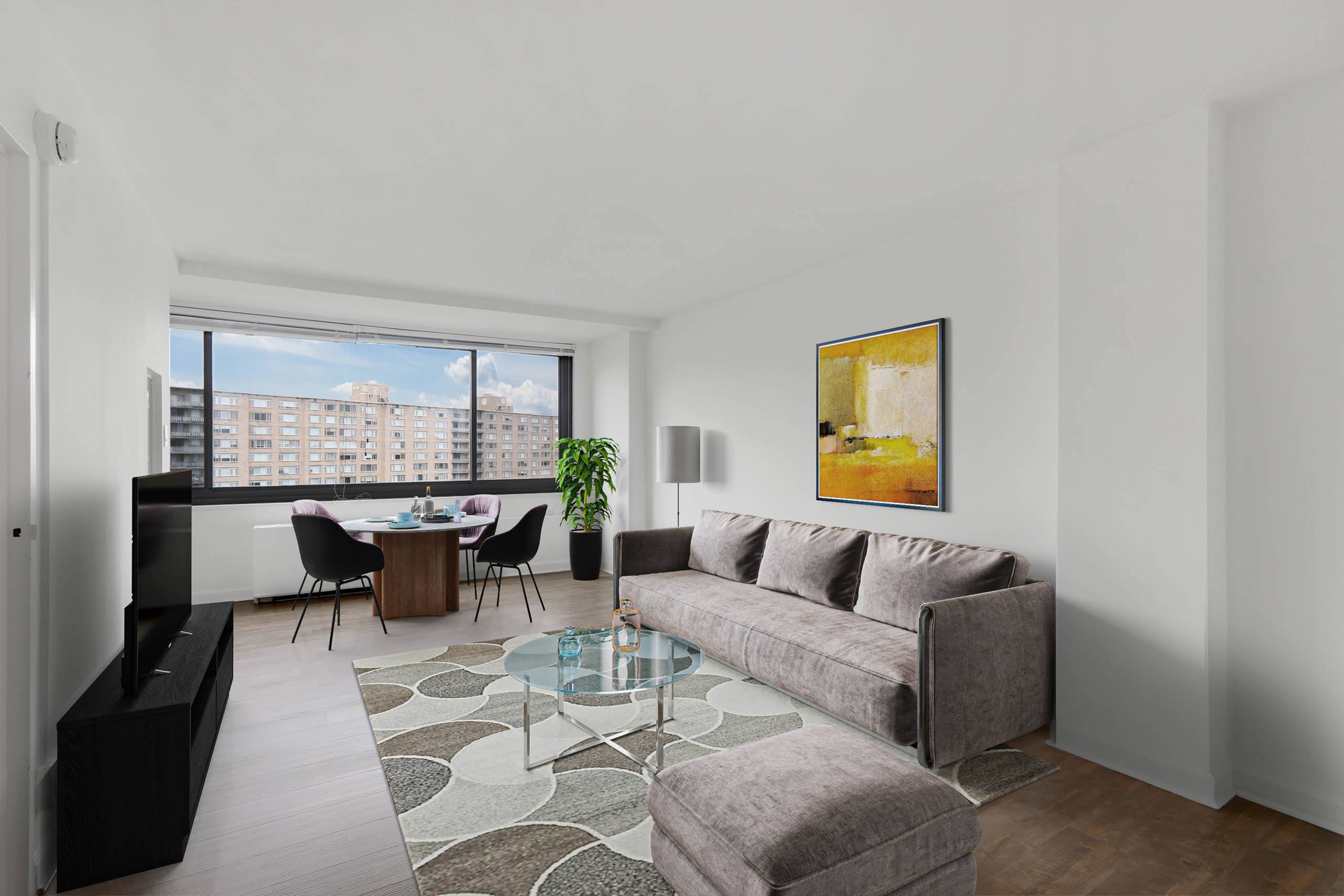A living room with a grey couch, a glass coffee table, and a painting on the wall.
