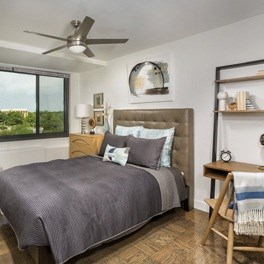 A bedroom with a large bed and a ceiling fan.