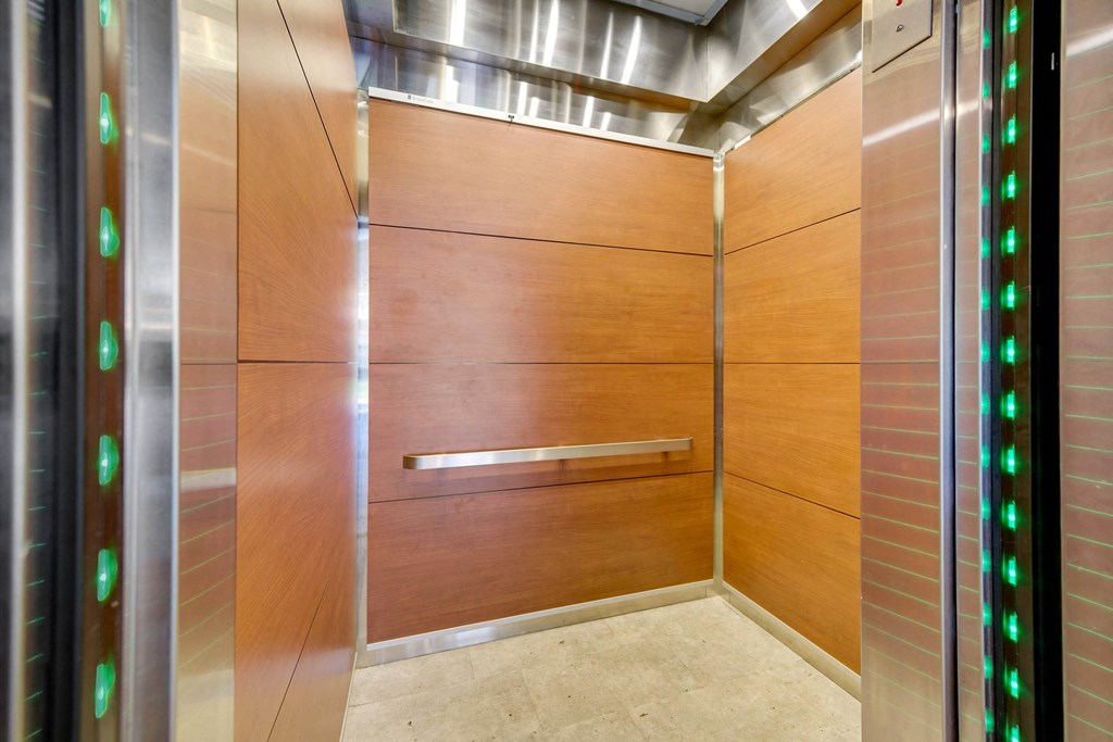 A modern elevator with green lights on the side. at The Lex At Lowry, Denver