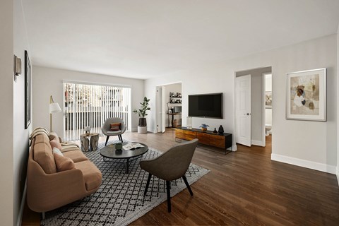 A living room with a brown sofa and a glass coffee table.