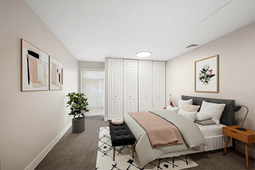 A bedroom with a large bed and a potted plant. at The Lex At Lowry, Colorado