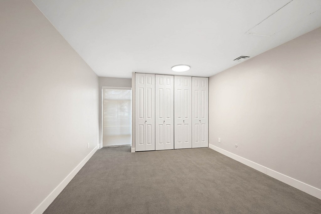 A room with a grey carpet and a white wardrobe. at The Lex At Lowry, Denver, Colorado
