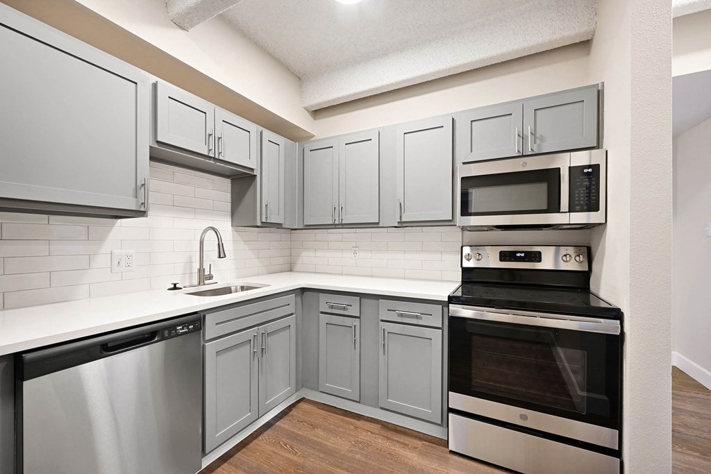 A kitchen with a stainless steel dishwasher and oven. at The Lex At Lowry, Denver, 80224