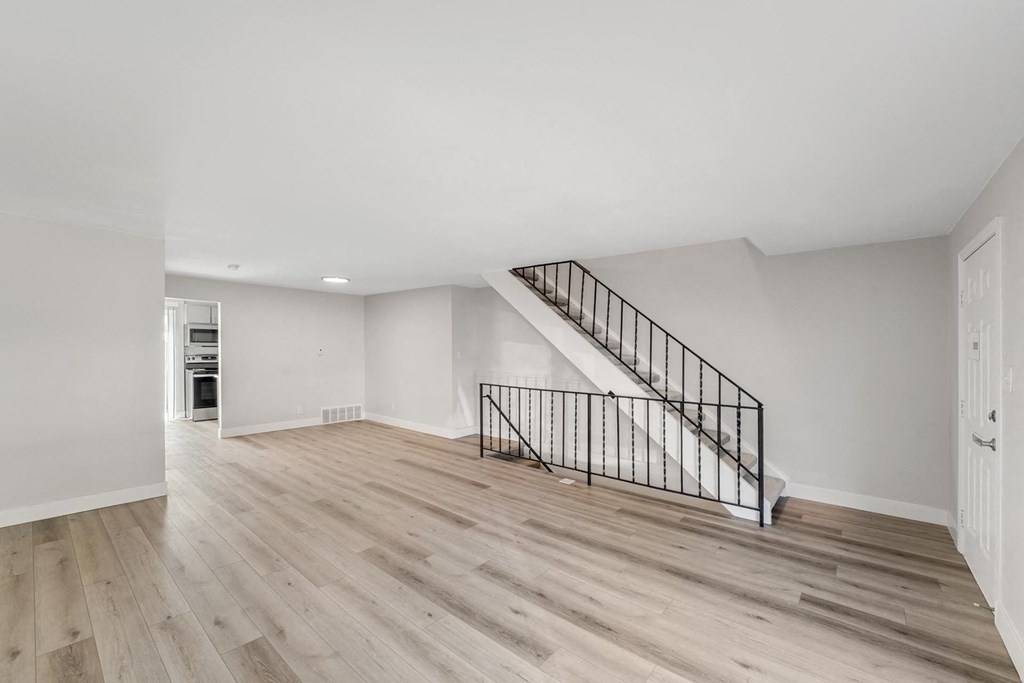A spacious room with a staircase and wooden flooring. at The Lex At Lowry, Denver, 80224